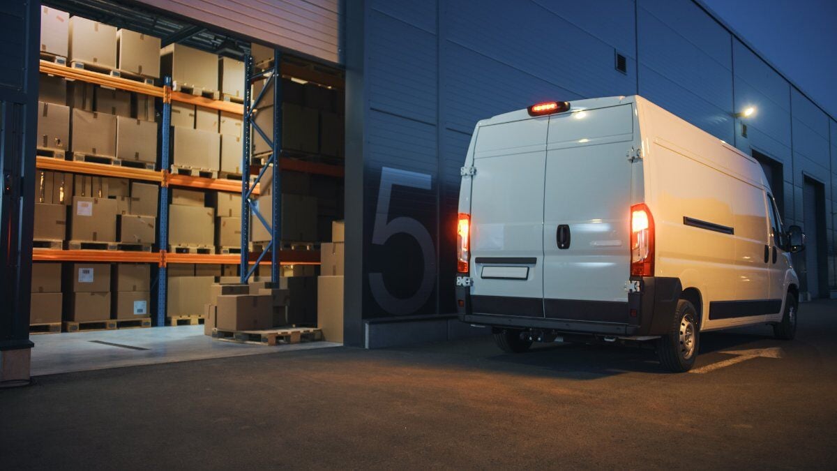 An open storage facility with a small delivery van parked outside
